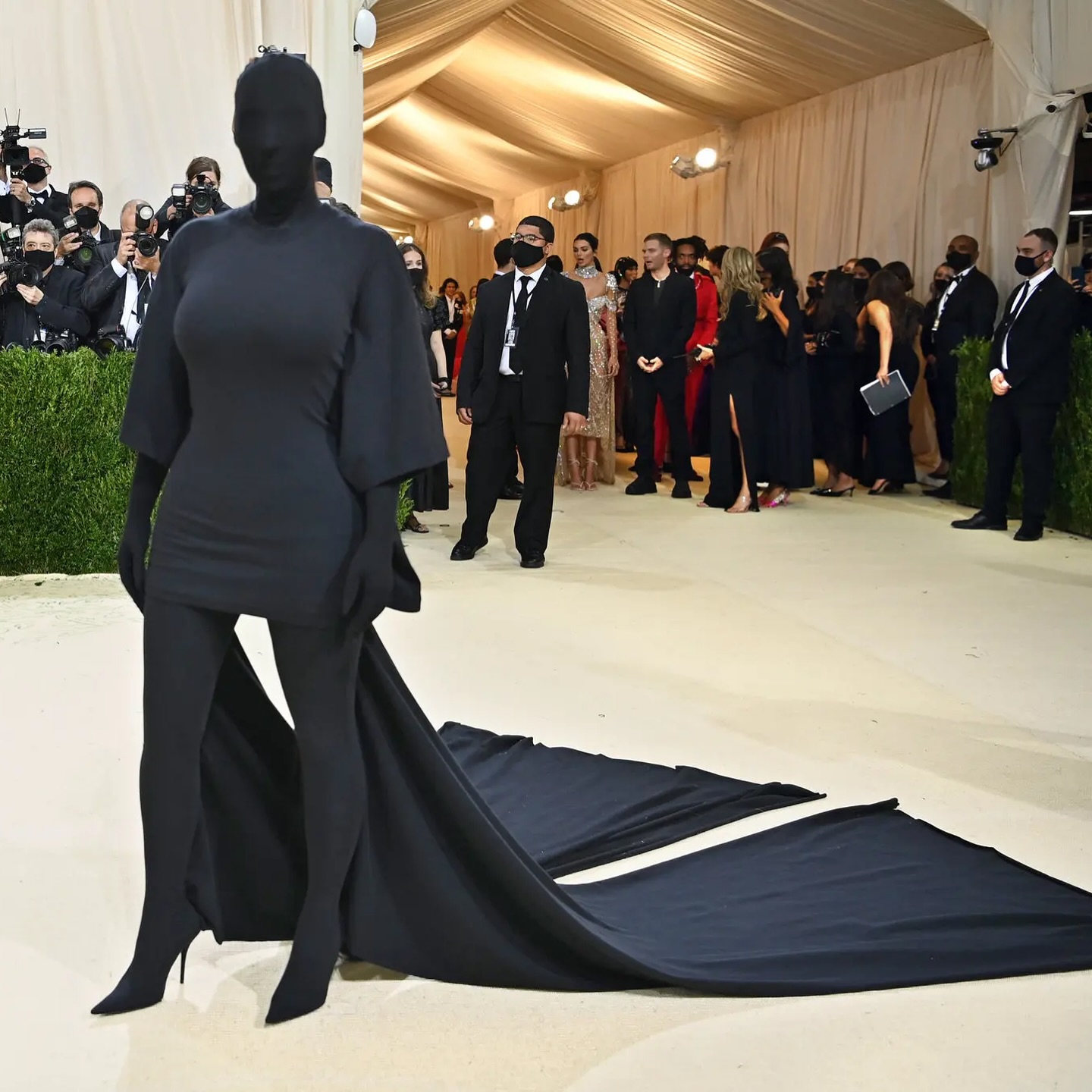 Foto da Kim Kardashian toda coberta de um tecido preto semelhante a malha no Met Gala 2021. Visual Balenciaga desenhado por Demna Gvasalia.