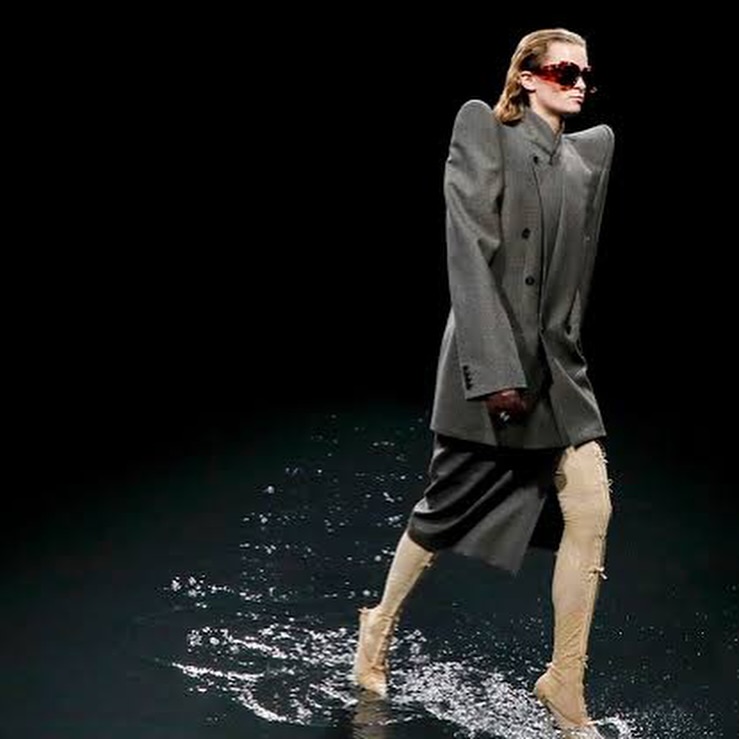 Modelo usando roupa da Gucci na NYFW. Roupa possui shape com ombreiras ponteagudas e manga solta.
