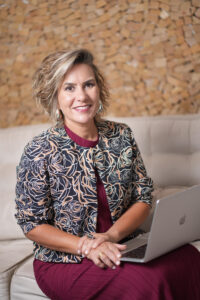 Foto da silvia scigliano com um notebook no colo.